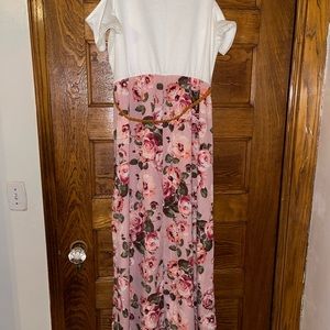 A long dress with a flower print on bottom and a stretchy white top.